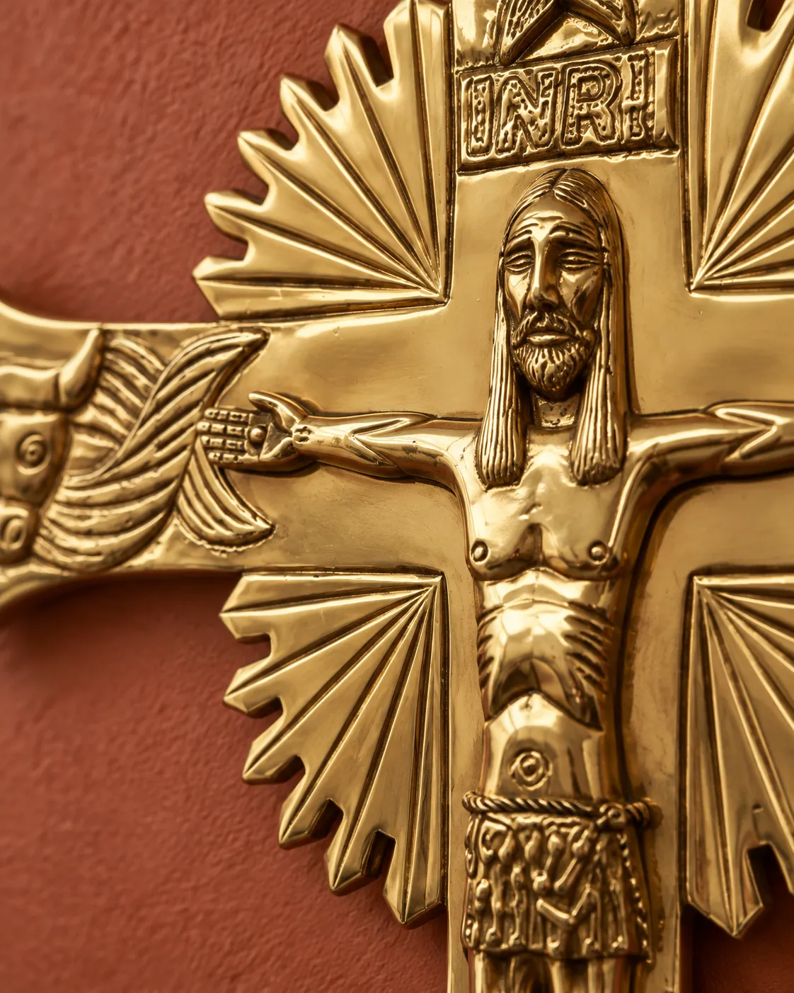 Detalle del INRI, el rostro de Cristo y los símbolos del ángel, el toro y el león, en la parte superior de la cruz